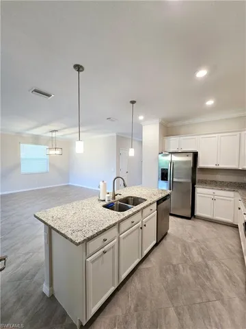 a kitchen with stainless steel appliances granite countertop a sink stove and refrigerator