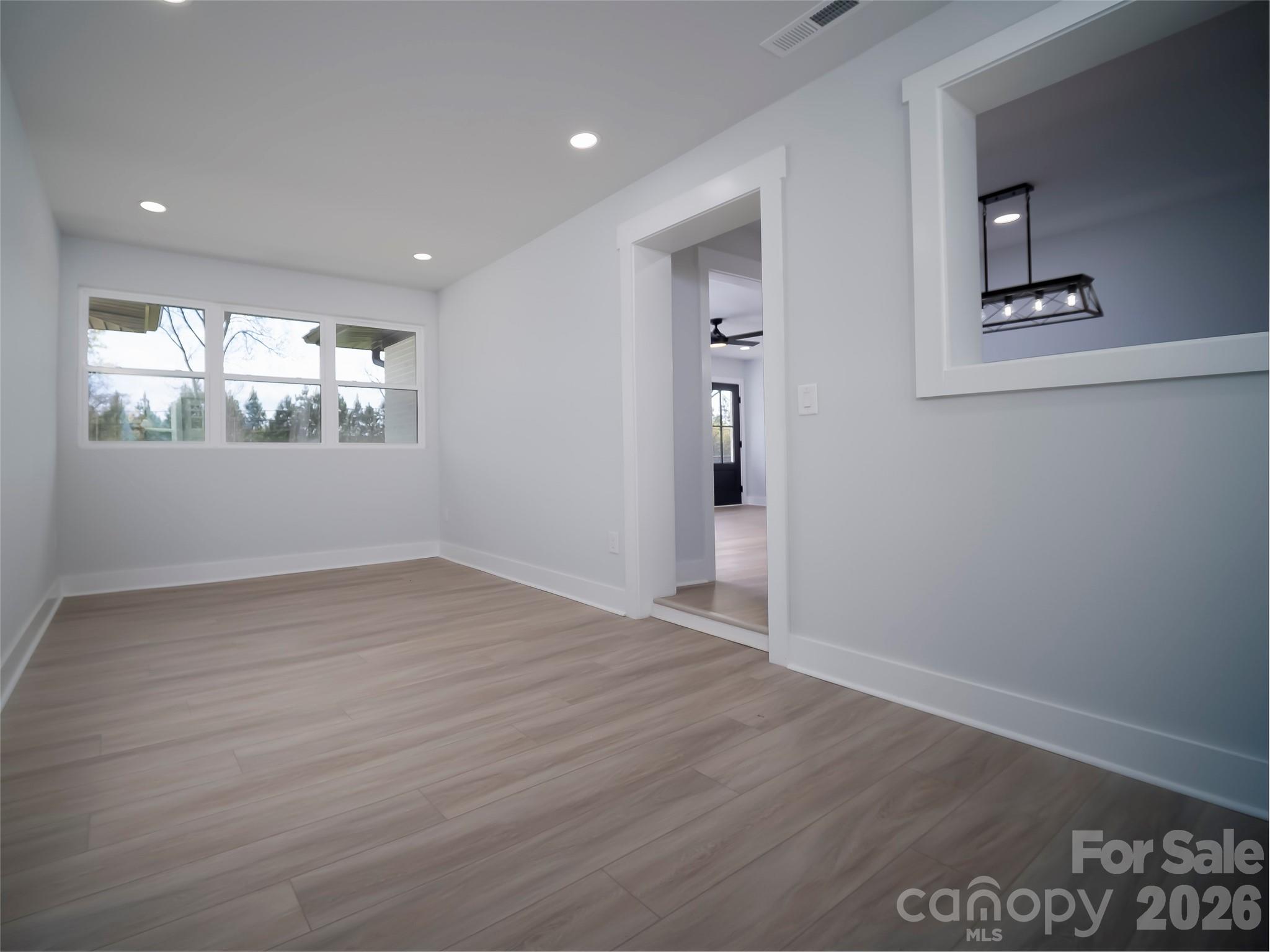 1325 Armstrong Road Belmont, NC 28012 - Photo 10 of 33 an empty room with wooden floor and windows