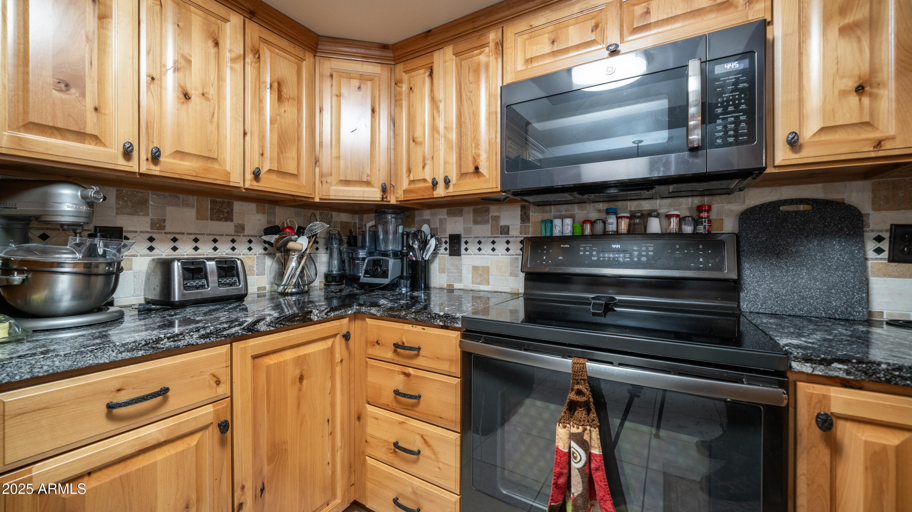 657 South Copper Drive Apache Junction, AZ 85120 - Photo 11 of 44 a kitchen with granite countertop a stove and cabinets