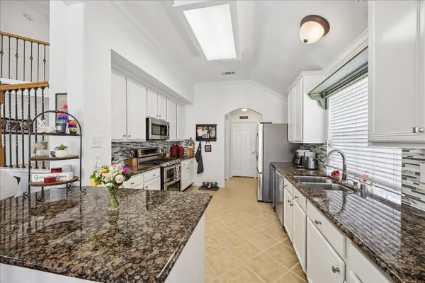 a kitchen with stainless steel appliances granite countertop a sink dishwasher stove and refrigerator