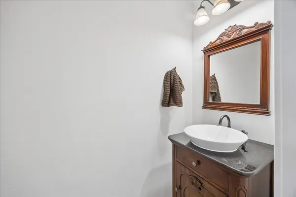 a bathroom with a granite countertop sink and a mirror