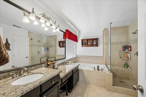 a bathroom with a granite countertop double vanity sink a mirror and shower