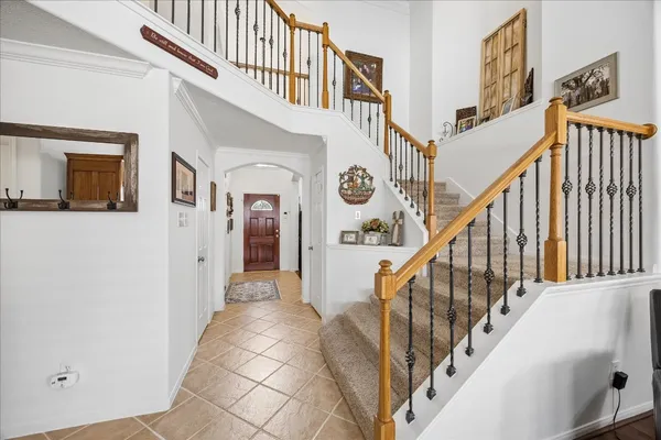 a view of staircase with lots of frames on wall and a window