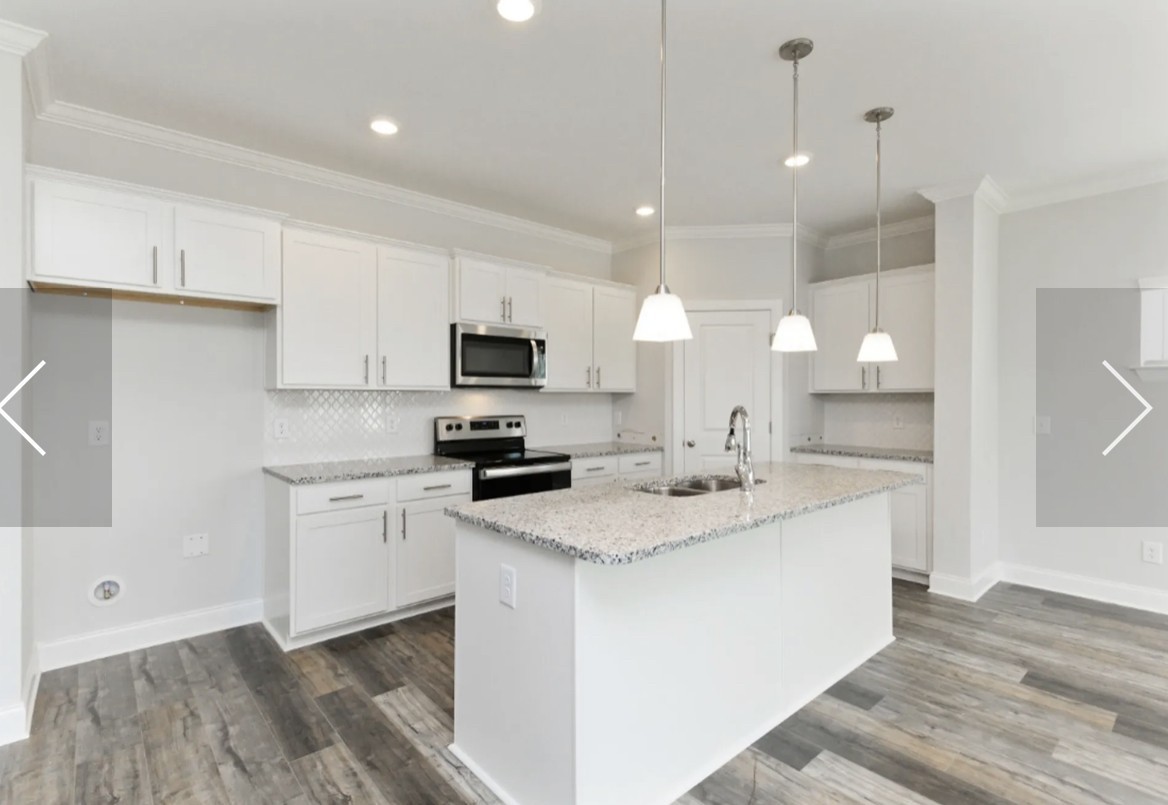 7132 Pepper Tree Circle Fairview, TN 37062 - Photo 3 of 14 a kitchen with stainless steel appliances granite countertop a sink a stove a refrigerator and white cabinets with wooden floor