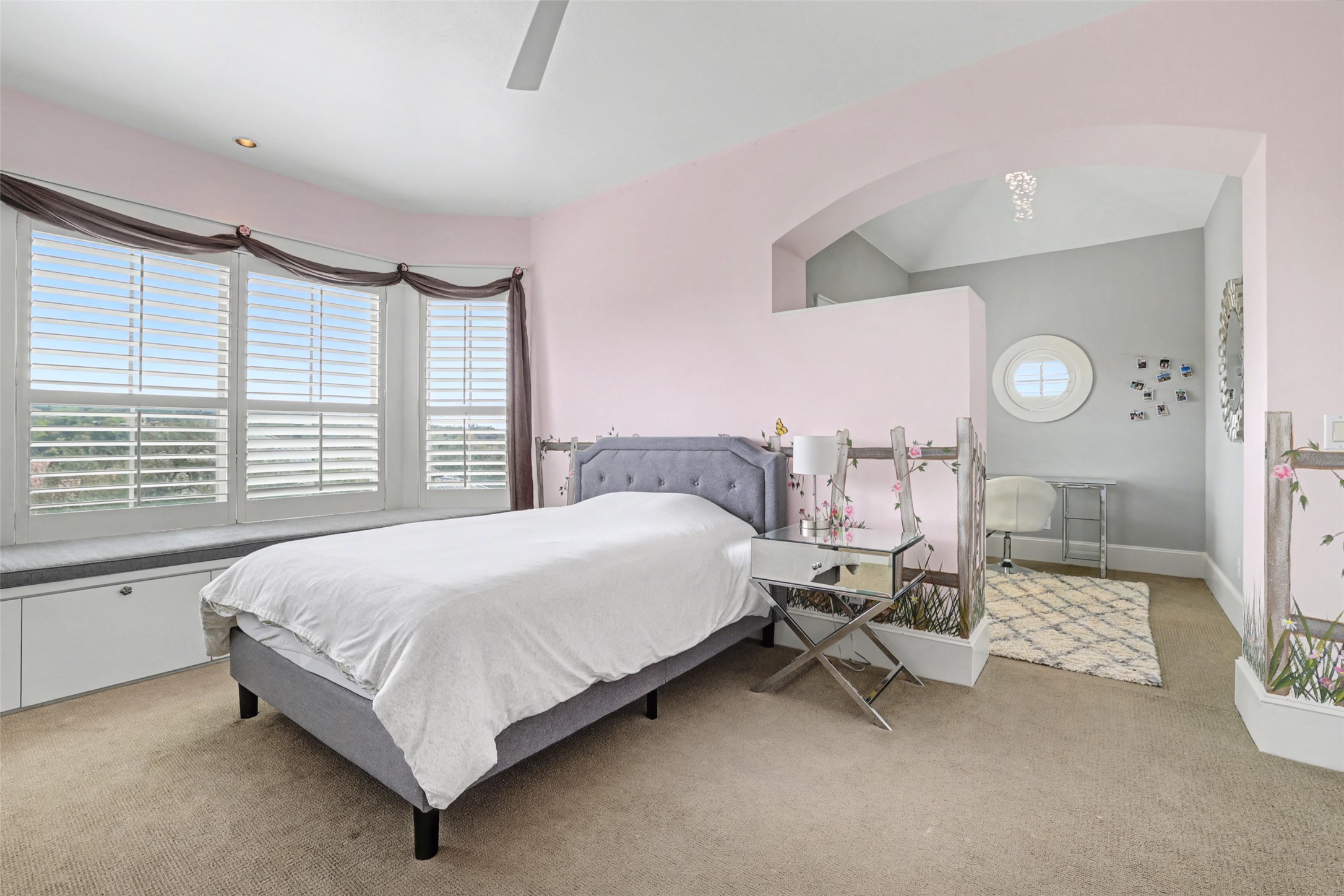 816 Stonewall Ridge Lane Austin, TX 78746 - Photo 24 of 32 A hand-painted beautiful English garden mural with birds, flowers, fairies grace this pink bedroom with a bay window with built-in storage bench.