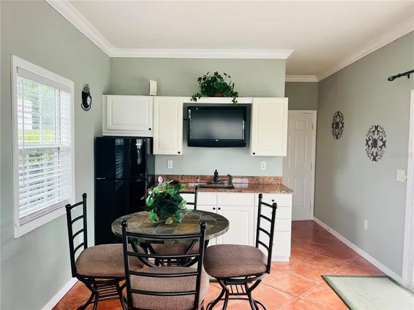 a kitchen with stainless steel appliances a dining table chairs and a refrigerator