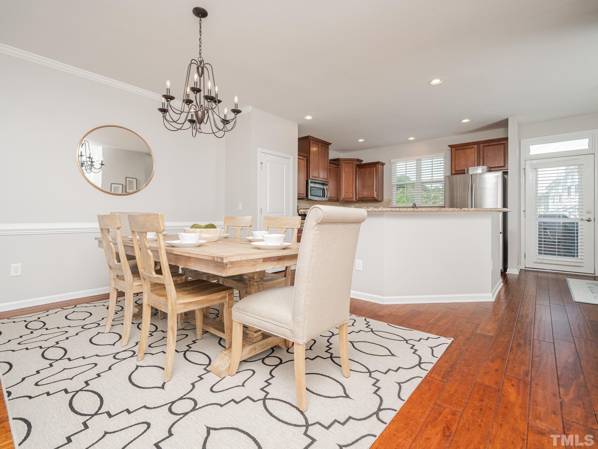 1307 Rodessa Run Raleigh, NC 27607 - Photo 13 of 36 a view of a dining room with furniture wooden floor and a chandelier