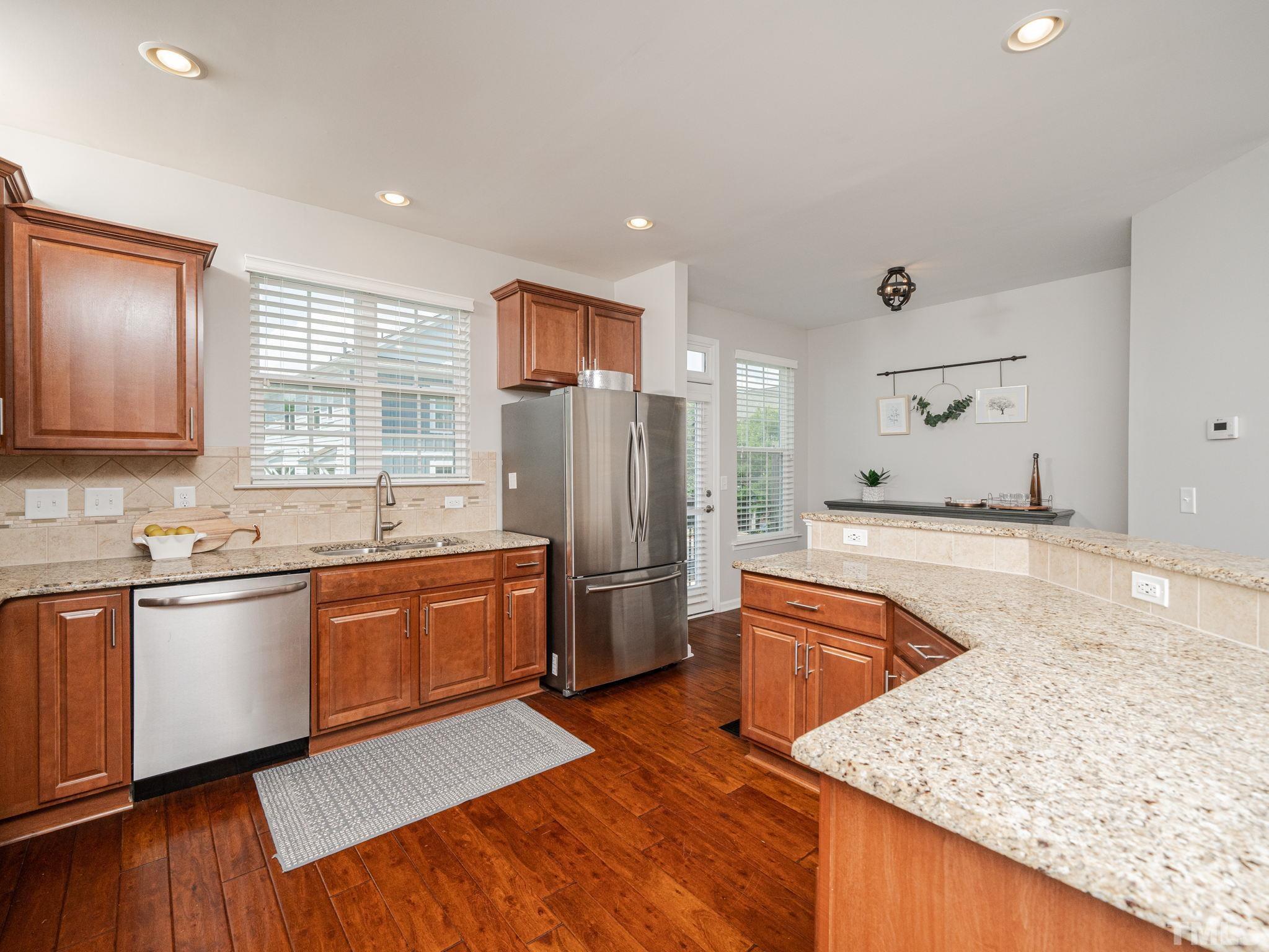 1307 Rodessa Run Raleigh, NC 27607 - Photo 15 of 36 a large kitchen with stainless steel appliances granite countertop a sink and dishwasher stove refrigerator a oven with wooden floors