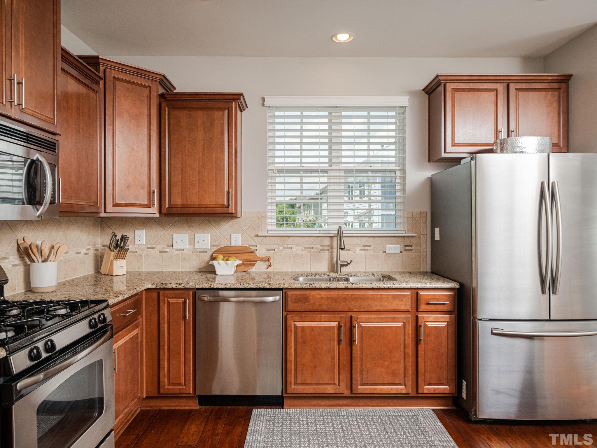 1307 Rodessa Run Raleigh, NC 27607 - Photo 16 of 36 a kitchen with stainless steel appliances granite countertop a refrigerator stove top oven and sink