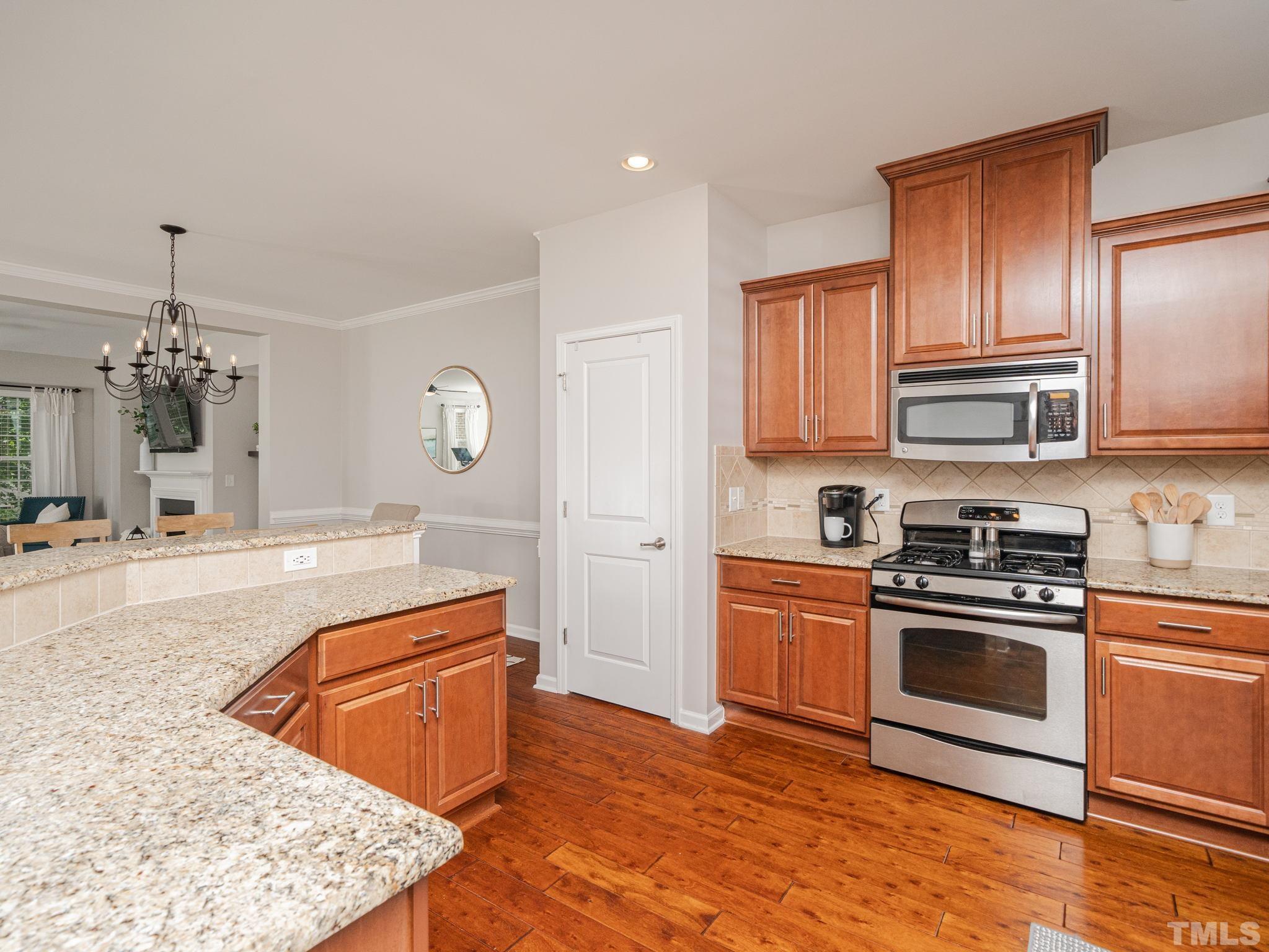 1307 Rodessa Run Raleigh, NC 27607 - Photo 17 of 36 a kitchen with stainless steel appliances granite countertop a stove a sink and a microwave