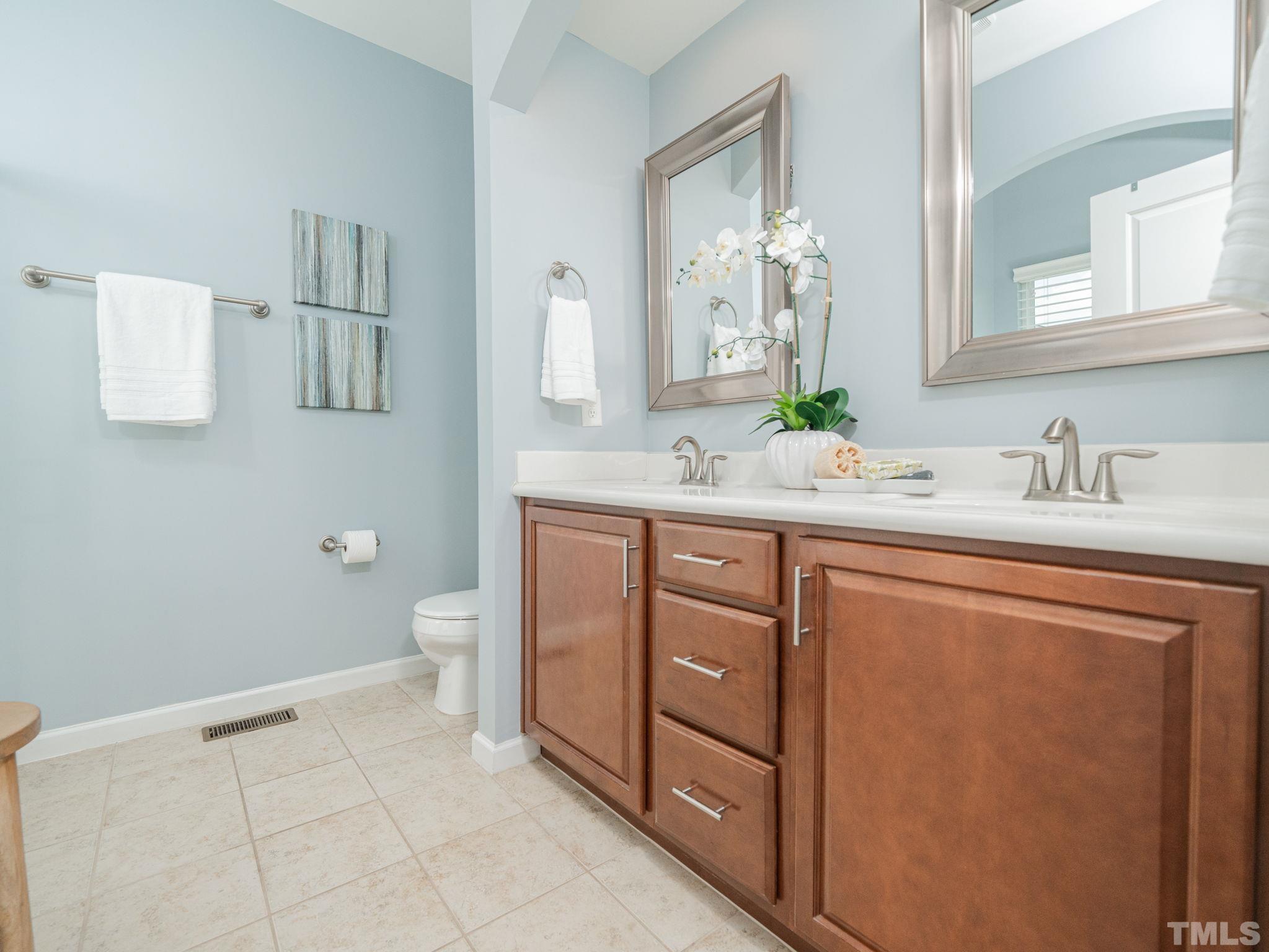 1307 Rodessa Run Raleigh, NC 27607 - Photo 23 of 36 a bathroom with a sink a toilet and mirror