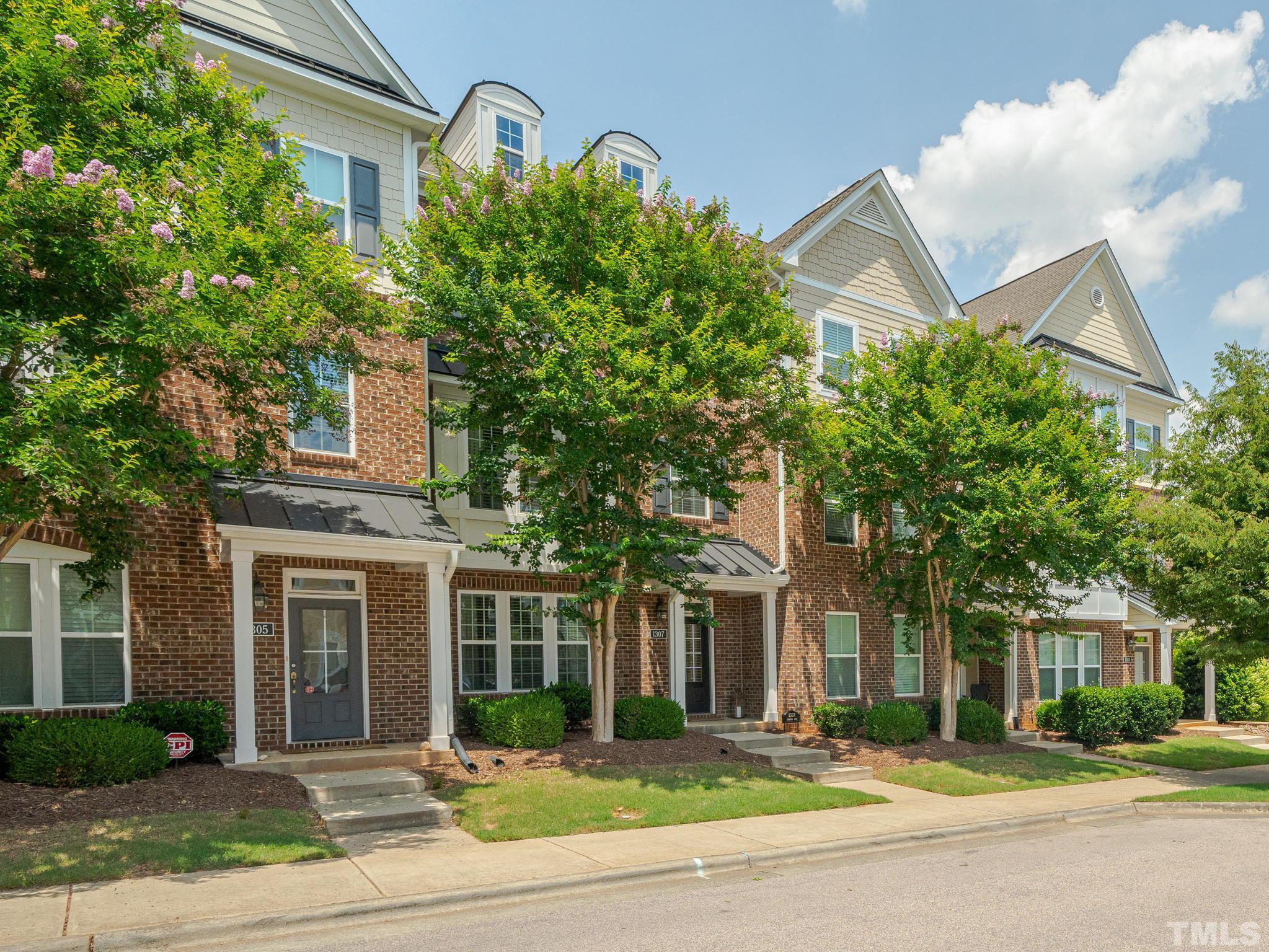 1307 Rodessa Run Raleigh, NC 27607 - Photo 34 of 36 front view of a brick house with a clock tower in middle