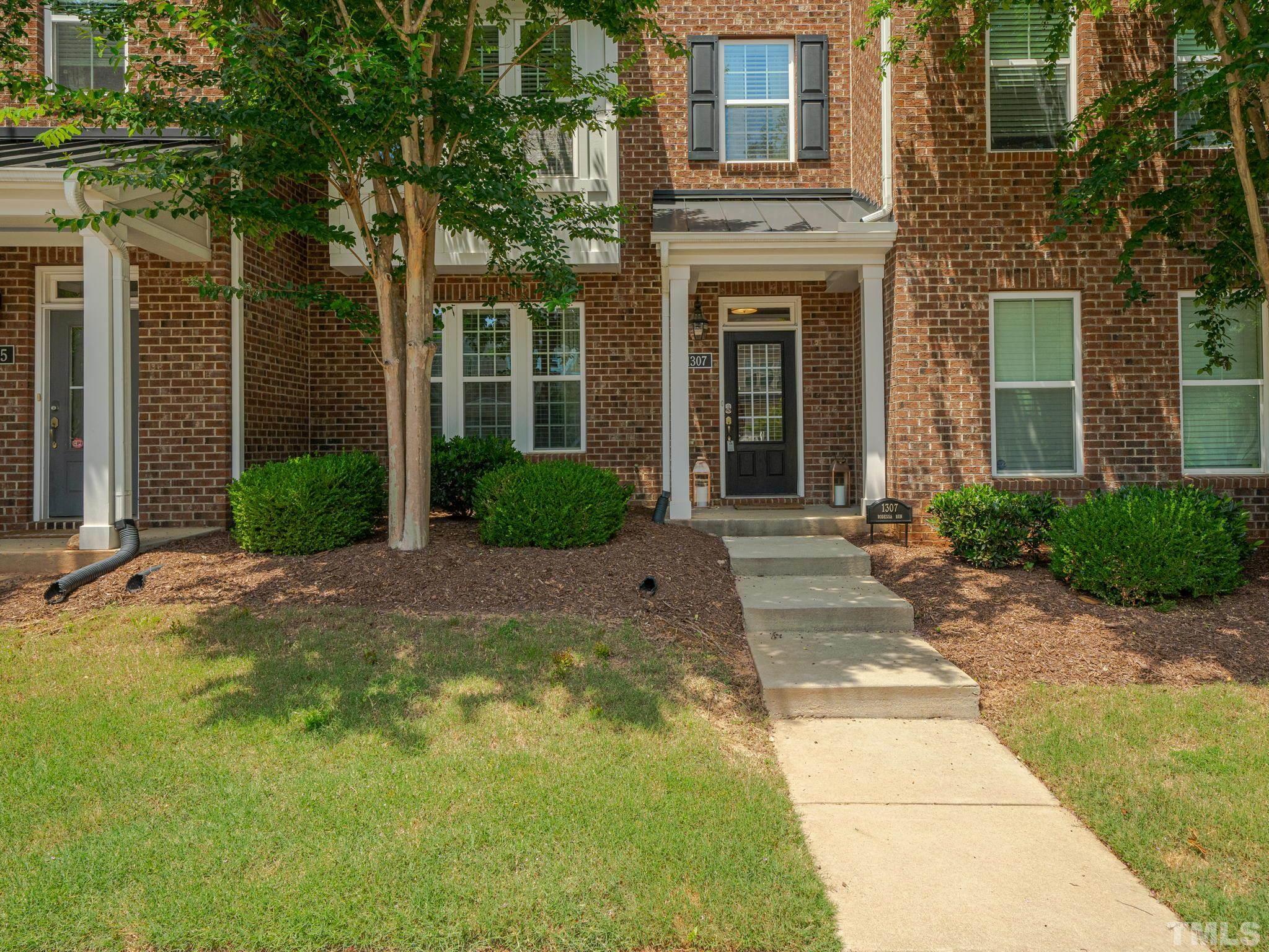 1307 Rodessa Run Raleigh, NC 27607 - Photo 36 of 36 a view of a brick house with many windows plants and large tree