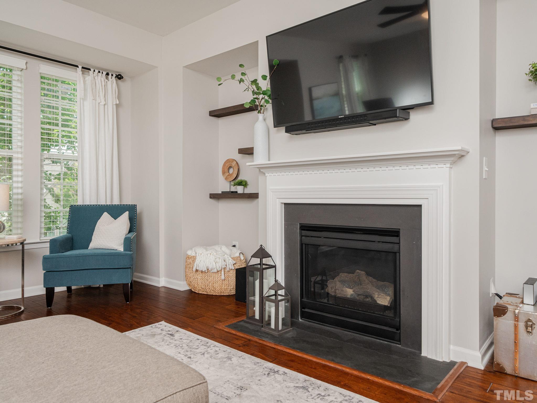 1307 Rodessa Run Raleigh, NC 27607 - Photo 10 of 36 a living room with furniture a flat screen tv and a fireplace