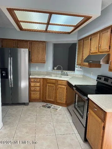 a kitchen with stainless steel appliances granite countertop a stove a sink and a refrigerator
