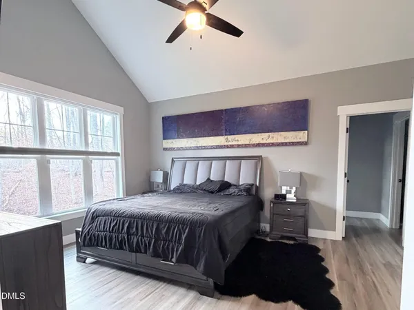 a bedroom with a bed lamp and a large window