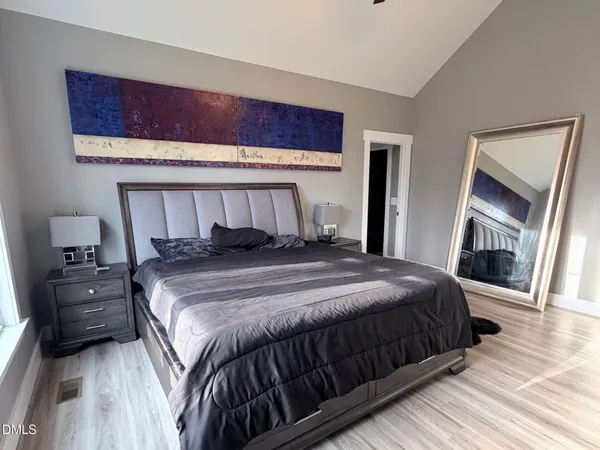 a bedroom with a bed and wooden floor