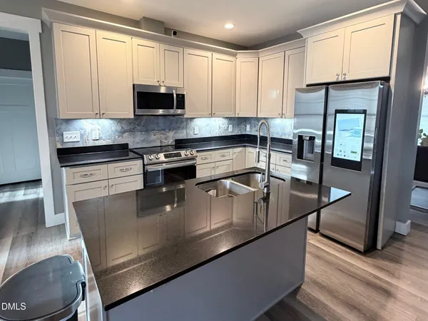 a kitchen with stainless steel appliances granite countertop a stove a sink and a microwave