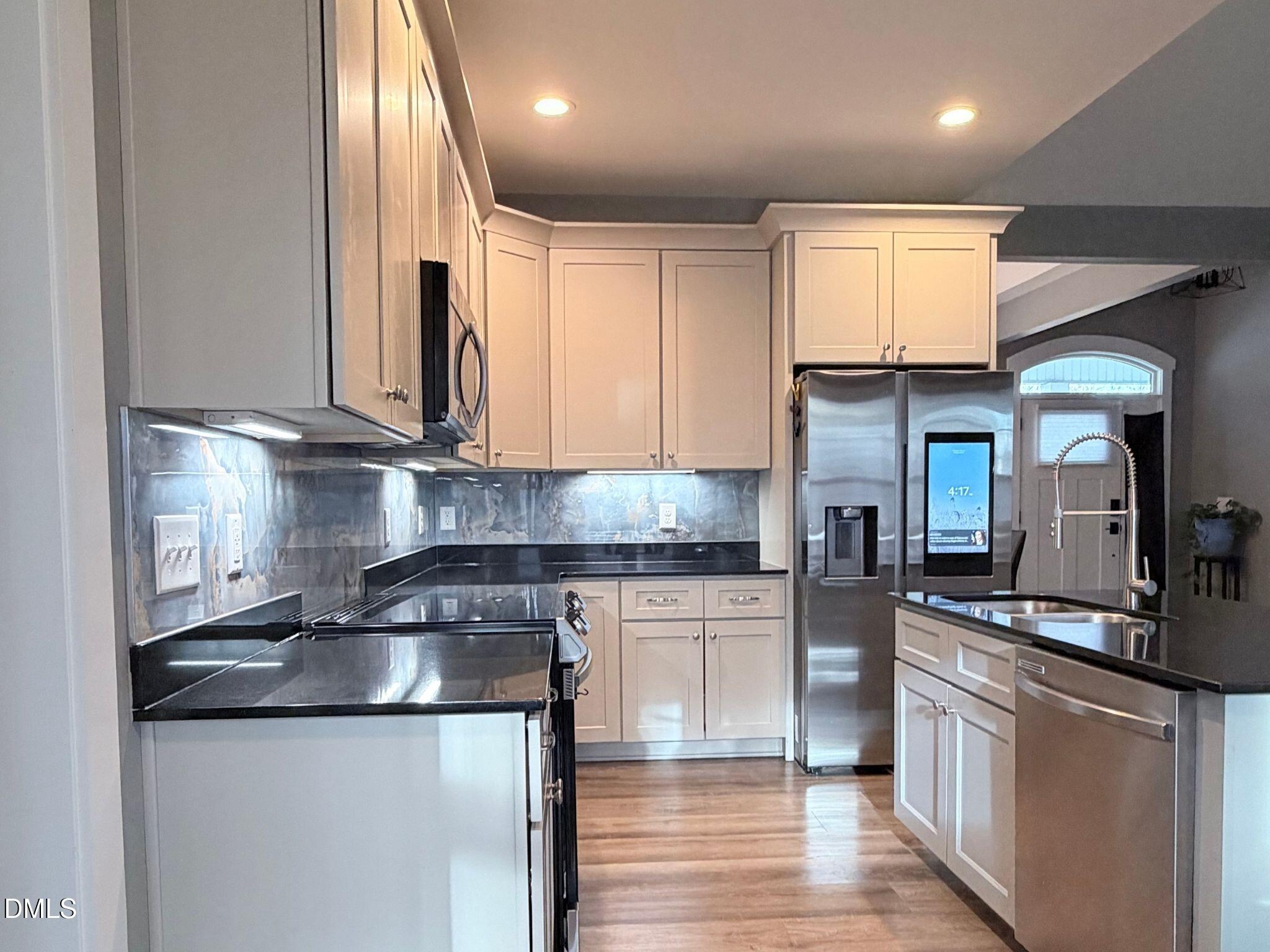 55 Running Deer Path Timberlake, NC 27583 - Photo 4 of 29 a kitchen with stainless steel appliances granite countertop a stove a sink and a refrigerator