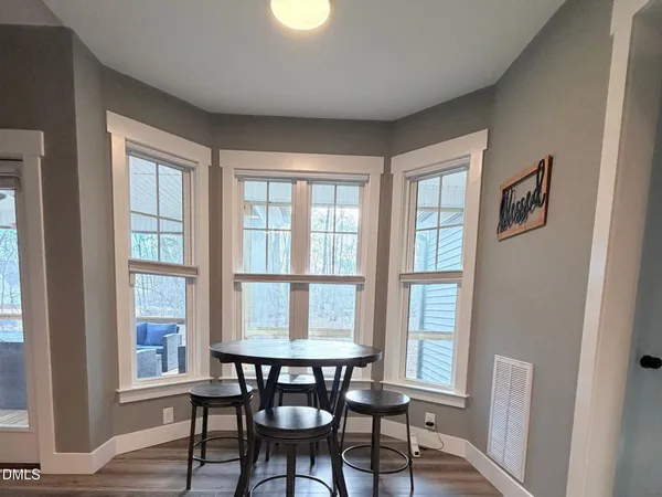 a view of a dining room with furniture windows and wooden floor
