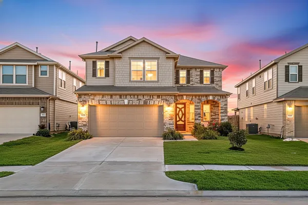 a front view of a house with a yard and trees