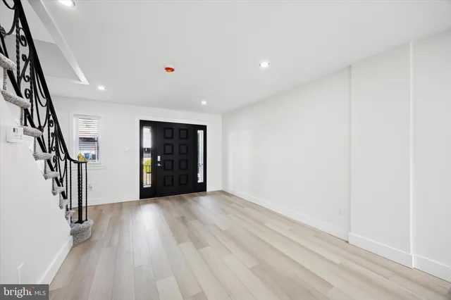 a view of an empty room with stairs and a window