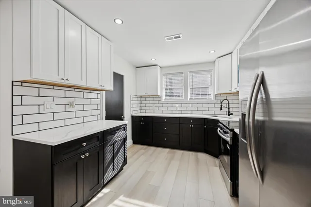 a kitchen with a sink refrigerator and cabinets