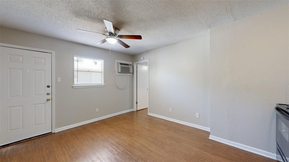 500 Foch Street, Unit 9 Bryan, TX 77801 - Photo 3 of 11 an empty room with wooden floor ceiling fan and windows