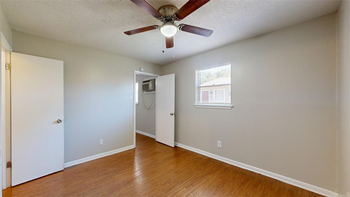 500 Foch Street, Unit 9 Bryan, TX 77801 - Photo 7 of 11 an empty room with wooden floor ceiling fan and windows