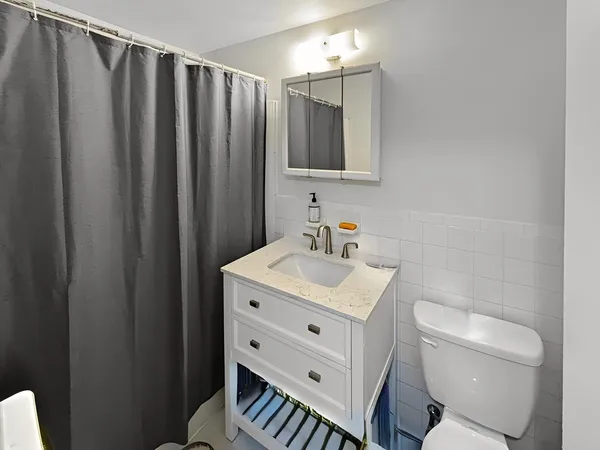 a bathroom with a toilet a sink and a mirror