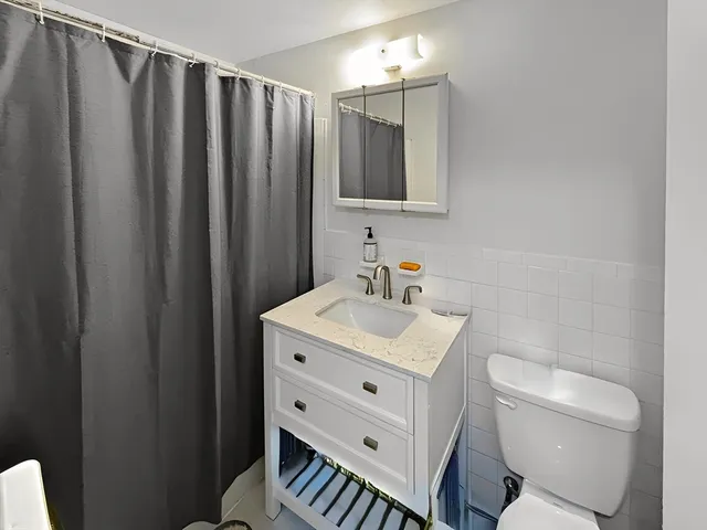 a bathroom with a toilet a sink and a mirror