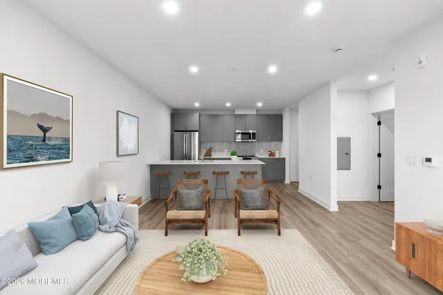 a living room with furniture and kitchen view