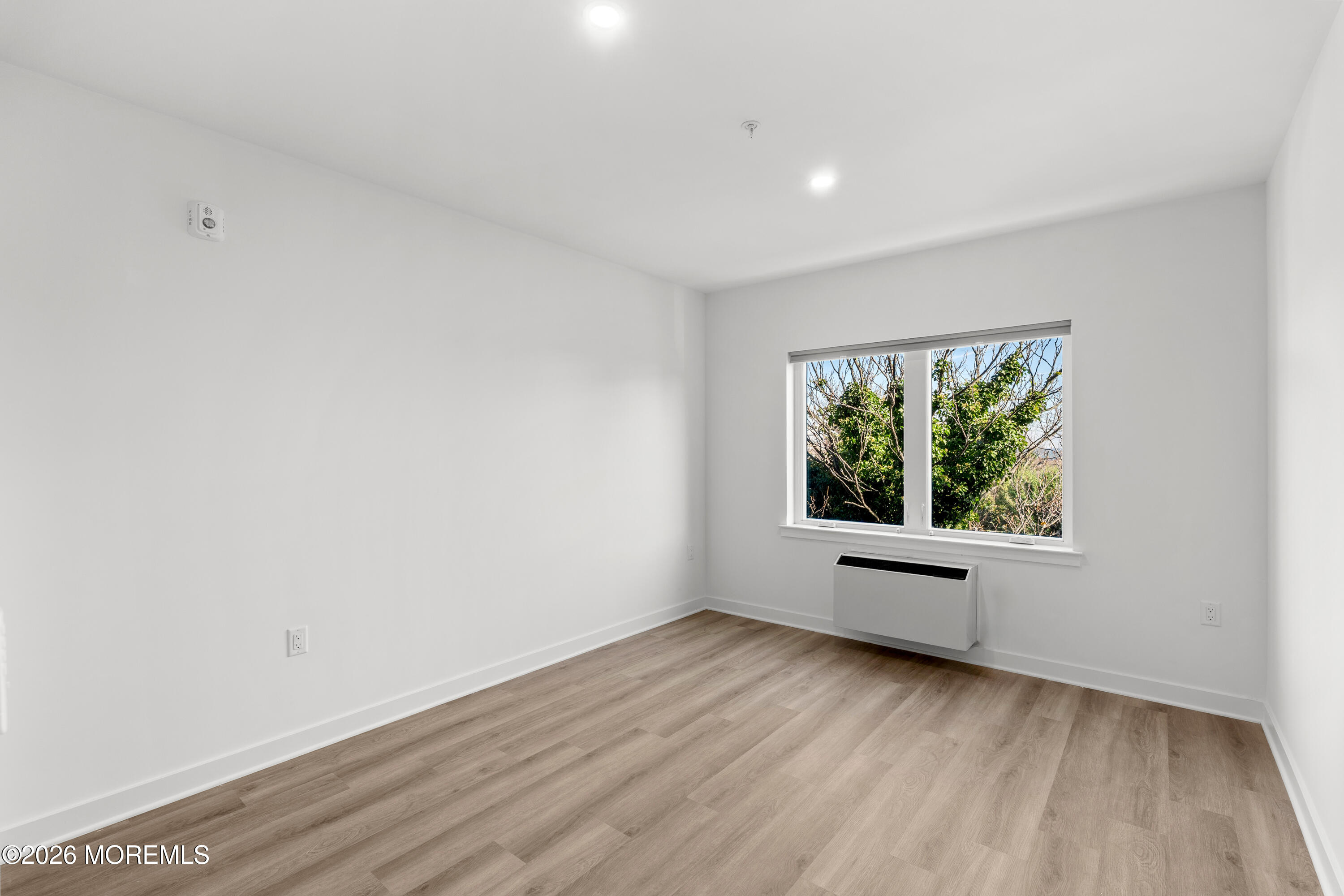 180 Morris Avenue, Unit 403 Long Branch, NJ 07740 - Photo 6 of 15 a view of an empty room with wooden floor and a window