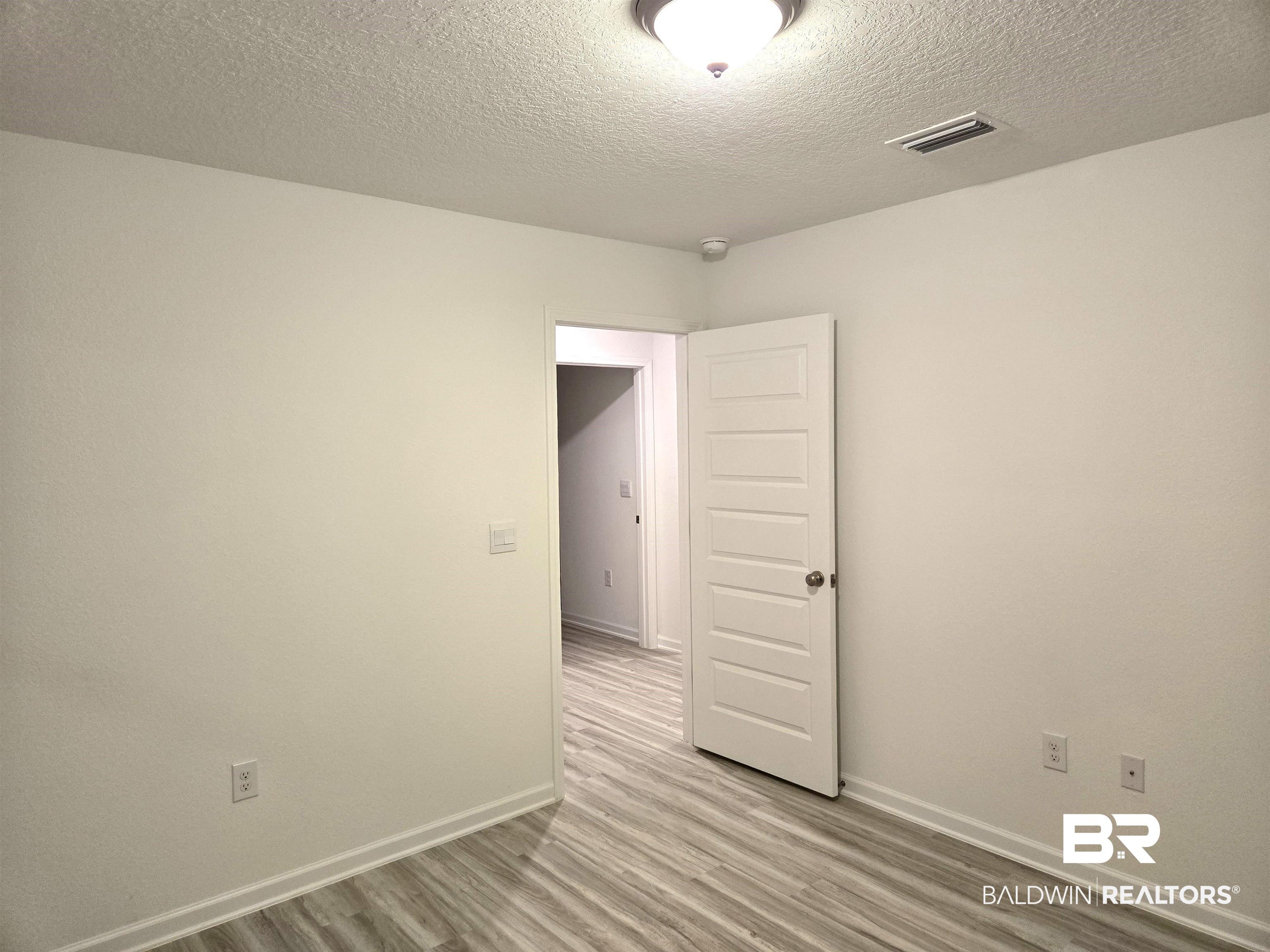 24385 Ringneck Loop Elberta, AL 36530 - Photo 26 of 33 Unfurnished room with light hardwood / wood-style floors and a textured ceiling