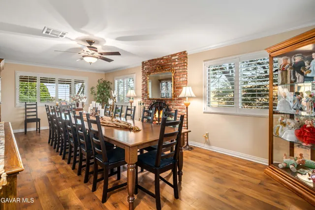 a dining hall with stainless steel appliances kitchen island granite countertop a dining table chairs and view living room