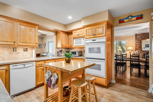a living room with lots of furniture and a view of kitchen