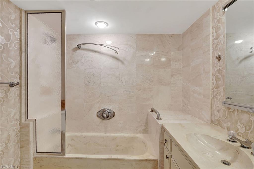 1919 Gulf Shore Boulevard North, Unit 201 Naples, FL 34102 - Photo 22 of 28 a bathroom with a sink and a shower
