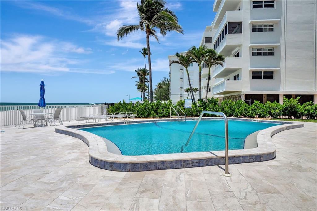 1919 Gulf Shore Boulevard North, Unit 201 Naples, FL 34102 - Photo 23 of 28 a view of a swimming pool with a yard