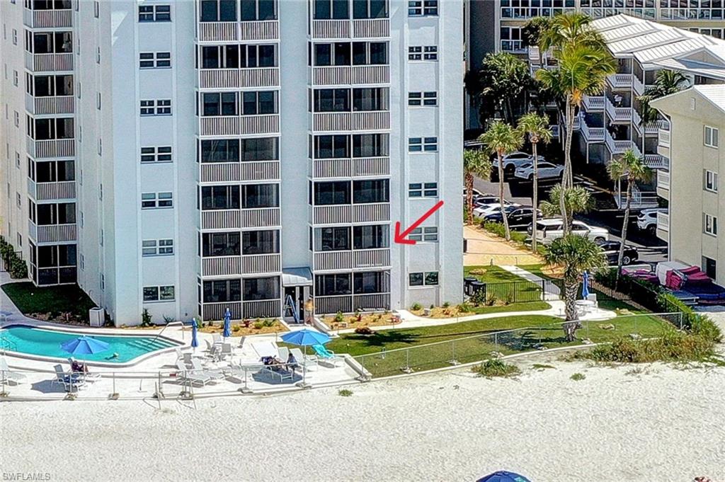 1919 Gulf Shore Boulevard North, Unit 201 Naples, FL 34102 - Photo 3 of 28 a table and chairs in front of building
