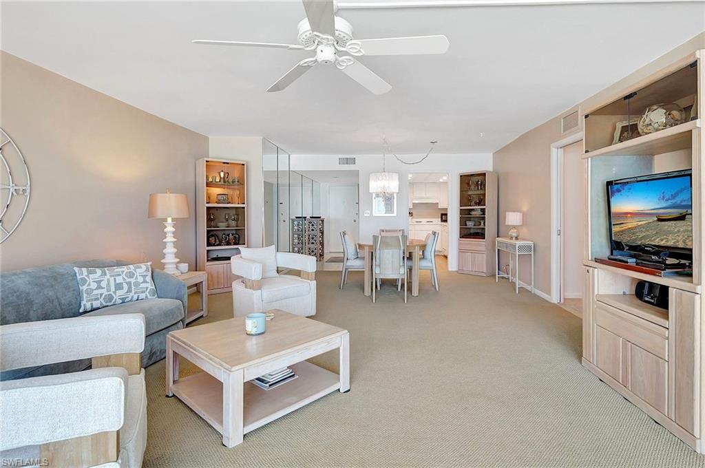 1919 Gulf Shore Boulevard North, Unit 201 Naples, FL 34102 - Photo 7 of 28 a living room with furniture and a flat screen tv