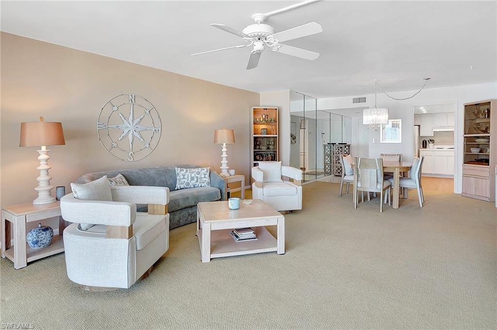 1919 Gulf Shore Boulevard North, Unit 201 Naples, FL 34102 - Photo 9 of 28 a living room with furniture and a chandelier