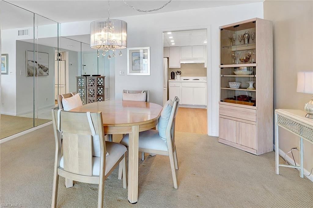 1919 Gulf Shore Boulevard North, Unit 201 Naples, FL 34102 - Photo 10 of 28 a view of a dining room with furniture and chandelier