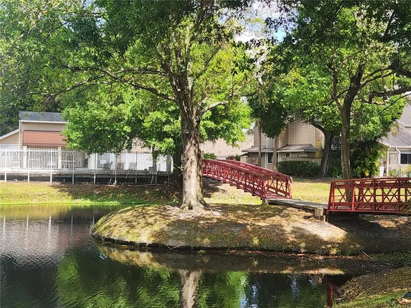 a view of swimming pool with lawn chairs and wooden fence