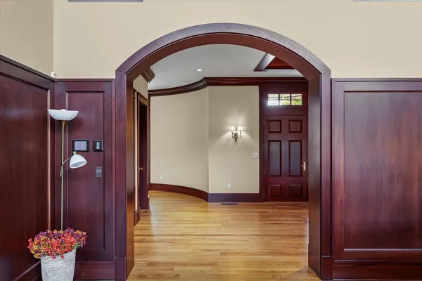 a view of a hallway with wooden floor and furniture
