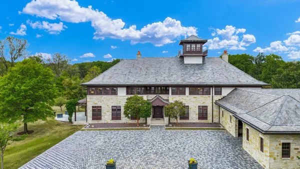 a view of a dining room with furniture a chandelier and window