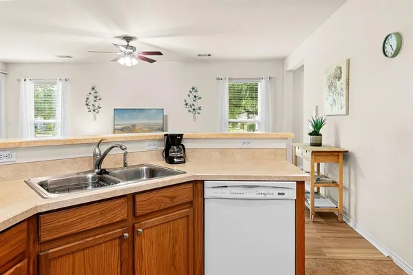 a kitchen with stainless steel appliances granite countertop a refrigerator a sink and white cabinets