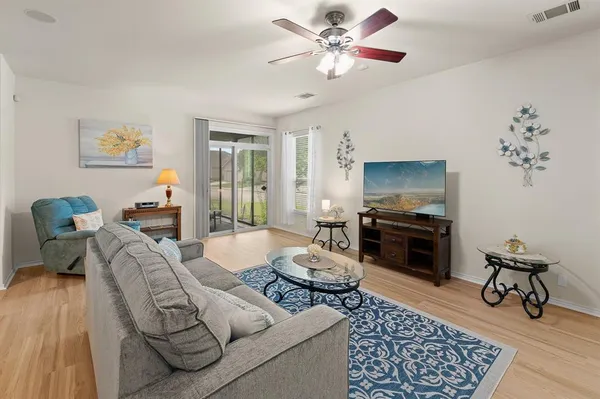 a living room with furniture a dining table and a flat screen tv with kitchen view