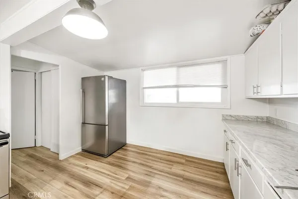 a view of a kitchen cabinets and a refrigerator