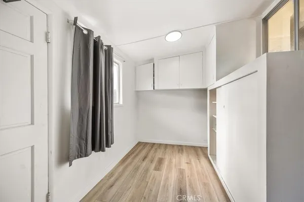 a view of a room with wooden floor and a window