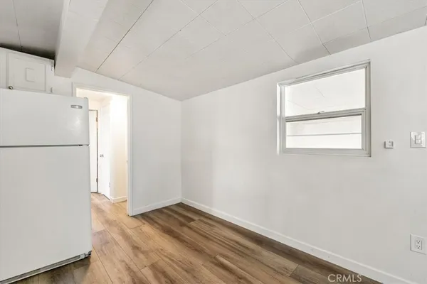 a view of empty room with wooden floor and window